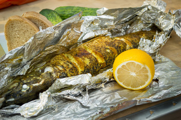 the baked pike served on a table with a lemon