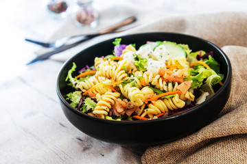 Salad with fusilli pasta accompanied tomatoes, mozzarella, smoked ham and italian cheese