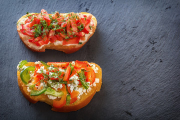 Bruschetta with fresh tomatoes, sweet pepper and goat cheese on white boards. Top view. Copy space