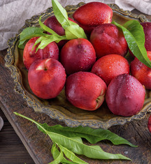 red ripe peaches nectarine in an iron plate