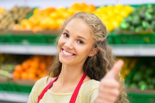 Portrait of a Female Shop Assistant Showing Thumb Up - Powered by Adobe