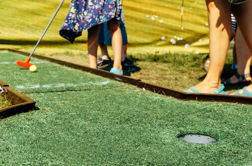 child playing golf, ball in motion, close-up hole