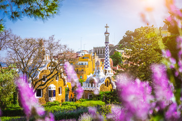 Fairytale house in Park Guell in bright purple lavendel flowers frame. Famous location summer...