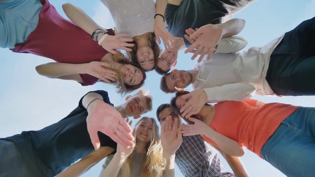 A group of friends of students look down and wave their hands.