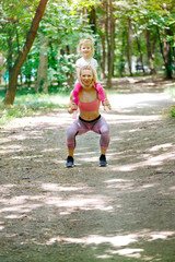 Mother and daughter exercise together in park. Piggyback, Sport, Family, Healthy lifestyle
