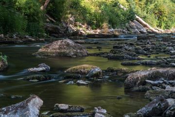 Naklejka na ściany i meble Keila River flowing between rocks in the forest