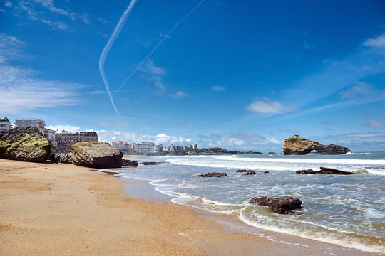Biarritz city and its famous sand beaches - Miramar and La Grande Plage with ocean waves , Bay of Biscay, Atlantic coast, Basque country, France. Summer sunny day and blue sky with airplane trail
