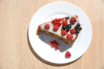 a cake with raspberry, black currant  and red currant on a white