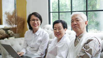 Asian senior couple consult and discuss health plan with woman doctor at home