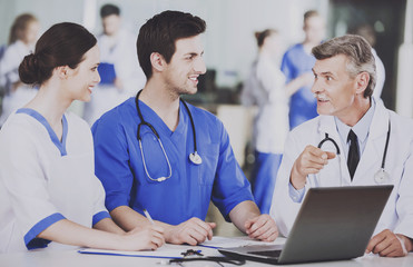 Group of Doctors with Laptop Discusses Operation.