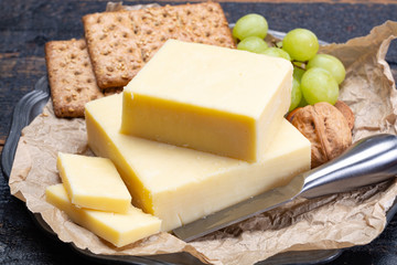 Block of aged cheddar cheese, the most popular type of cheese in United Kingdom and USA, natural cheese made from cow milk