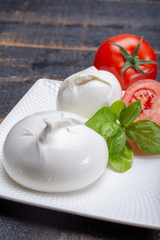 Fresh soft white burrata, ball buttery cheese, made from a mix of mozzarella and ricotta cream, original from Apulia region, Italy, very popular soft cheese in USA
