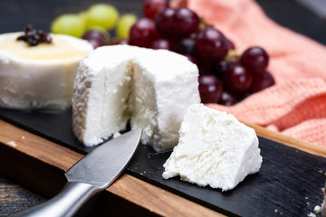 French soft cheeses, variety of different taste goat milk natural cheeses on granite plate close up sesrved as dessert