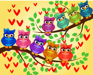 Cute multi-colored owls on a branch of a tree. Spring, summer, holiday