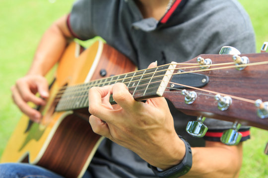 Musician playing guitar in the park