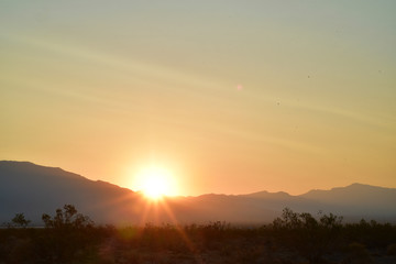 long exposure photos of the sun rising over the ridge of the Spring Mountains in the Mojave Desert town of Pahrump, Nevada, USA