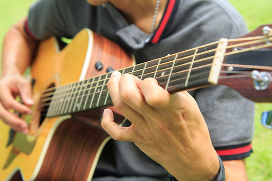 Musician playing guitar in the park