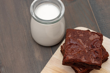 homemade cake chocolate brownies and milk on wooden table