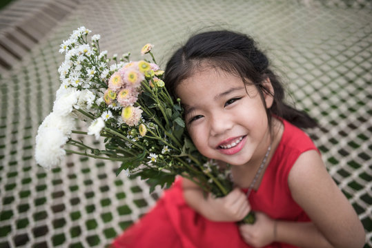 Adorable asian gril kid red gressing with flowers