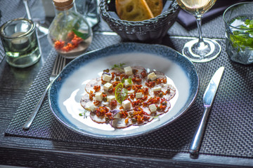 Carpaccio of octopus on blue plate