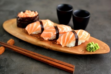 Sushi nigiri with raw fresh salmon on a wooden board
