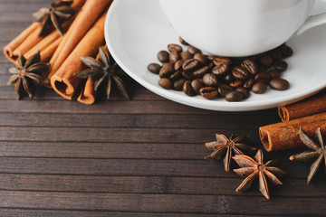 Cup with coffee beans and aromatic spices