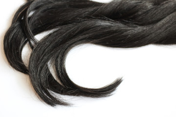 Lock of long, black hair, white background