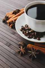 Cup with coffee beans and aromatic spices