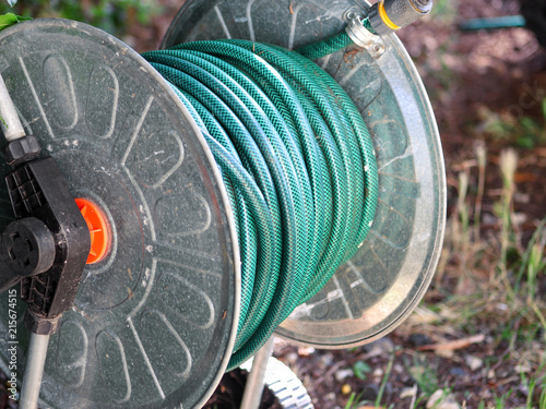Green Gardening Hose For Watering Flowers And Gr Wred Around Green Gardening Hose For Watering Flowers And Gr Wred Around The Aluminum Carrier Garden Compressed Plants In