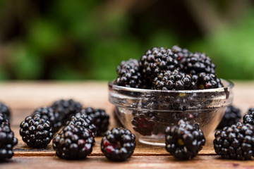 Fresh ripe blackberries in bowl on wooden table
