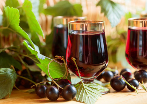 Homemade black currant liqueur and fresh berries.