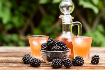 Fototapeta na wymiar Fresh blackberries and liqueur on wooden table