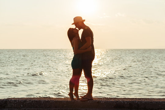 Young couple in love enjoying sunset on the beach