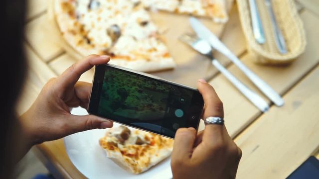 Female Food Blogger Taking Photos Of Pizza By Cellphone In Pizzeria