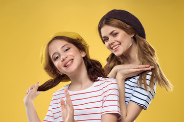 girlfriends in caps on a yellow background portrait