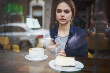 woman in a cafe with a phone