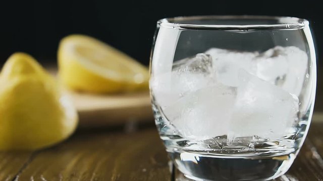 Ice cubes fall into a glass, slow motion. Cocktail concept.