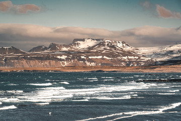 Snaefellsnes Weste Iceland Ocean view with beach and mountains and blue sky in the background.