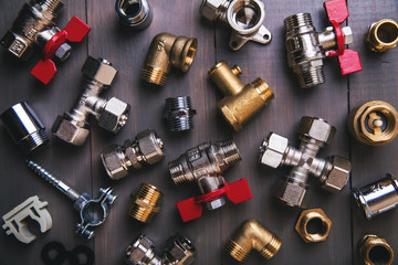 group of plumbing fittings and equipment on wooden background - obrazy, fototapety, plakaty