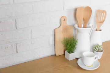 Kitchen utensils and dishware on wooden shelf. Kitchen interior background
