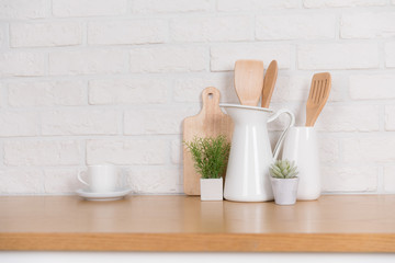 Fototapeta na wymiar Kitchen utensils and dishware on wooden shelf. Kitchen interior background