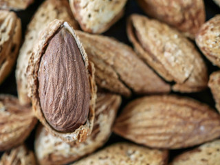Almond nut in shell and shelled on wooden background