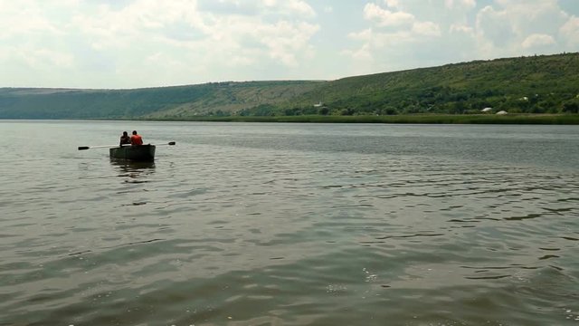 Two people on a boat floating on the river