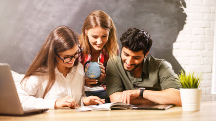 Young happy three friends with the globe tablet and passports, they choosing place for travel