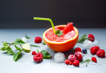 Cocktail drink with grapefruit, berries and ice cubes