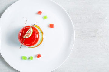 Watermelon dessert. Panakota and jelly in a white plate on the table background. Top view