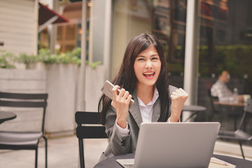 Business Concept.Young Asian businesswoman is working happily.Young businesswoman working in a cafe.Young businesswoman is relaxation in a coffee shop.