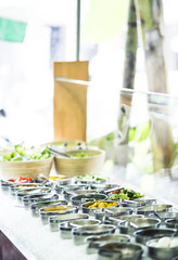 bowls of mixed fresh organic vegetables in salad bar display