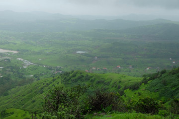 Fototapeta na wymiar lush green landscape of mountain and hills in monsoon season, Purandar, Maharashtra, India