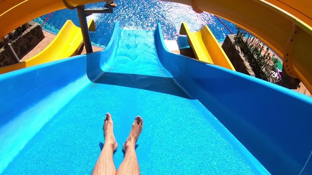 Professional video of point of view on the water slide in the water park in slow motion 120fps
